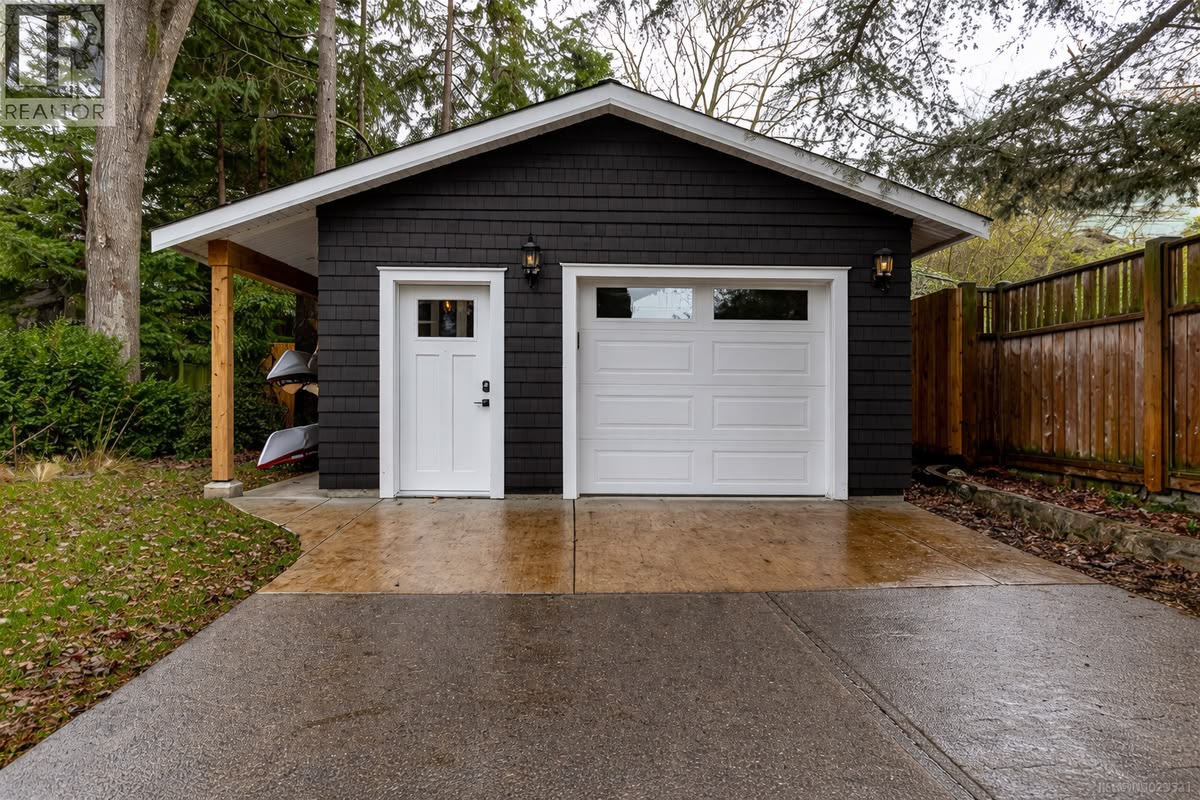 Modern custom detached garage in Calgary with dark exterior and white overhead door