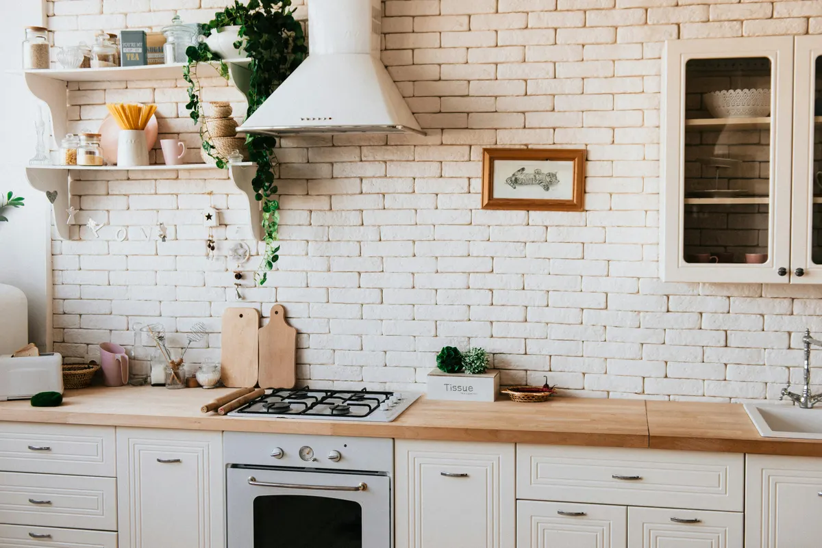 Warm kitchen design with exposed brick and butcher block counters - Ridgeline Renovations Calgary